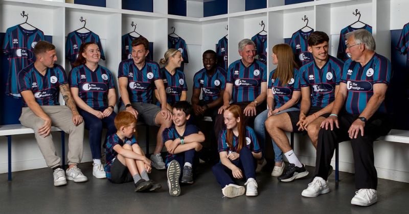 fans and players wearing hartlepool united 2023-24 away shirt in blue and teal